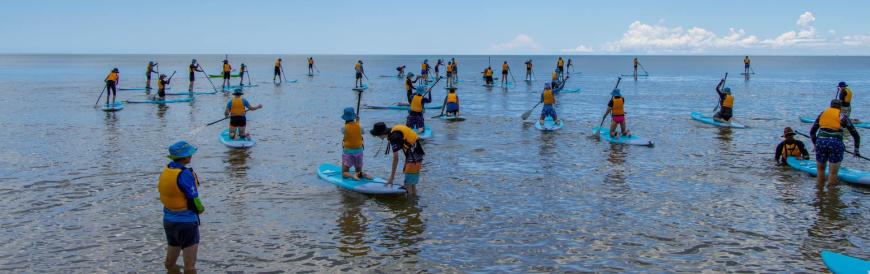 Large group of scouts on stand-up paddle boards