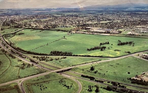 Areal view of open land between the train line and freeway