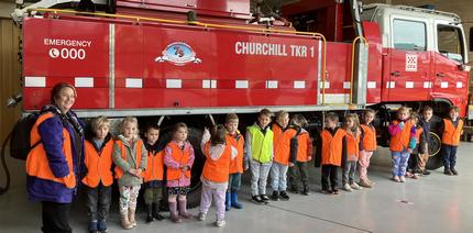 Preschool children lined up in front of a CFA tanker