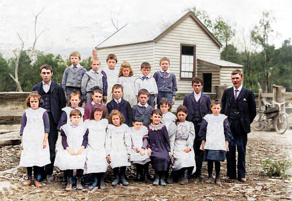 SChool buildings with students and teacher in front
