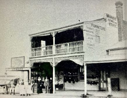 Two story weatherboard shop with veranda